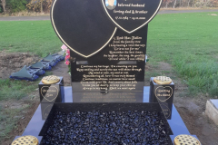 Curved-top black granite religious monument with engraved inscription