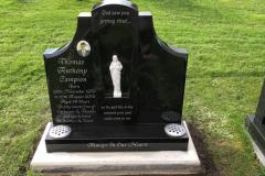 Black granite memorial with white figurine