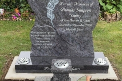 Dark grey granite heart-shaped headstone with engraved inscription