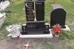 Black granite headstone with red flowers